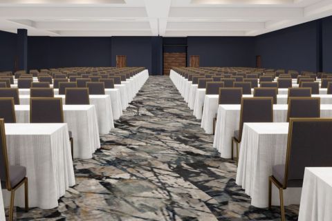 A conference hall with several tables and chairs