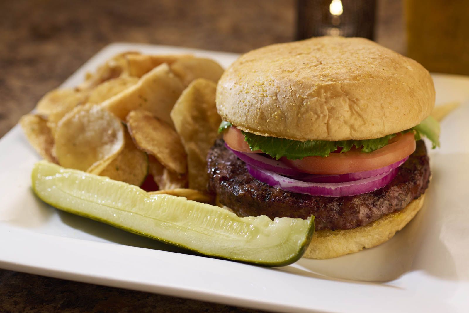 Hamburger served with pickle, french fries, and a beer