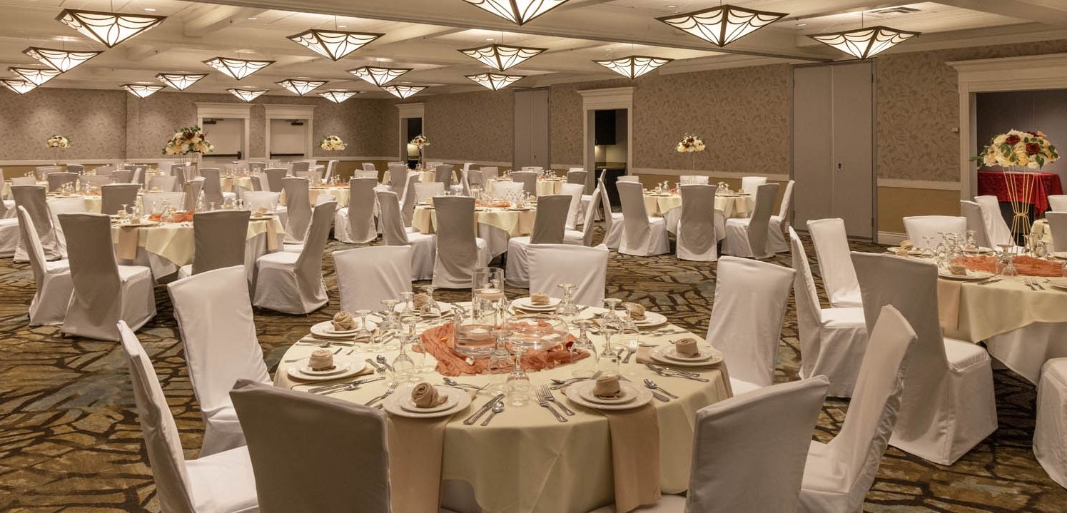 The Hotel Ithaca's massive ballroom set up for a formal meeting session with elegant white tablecloths and place settings